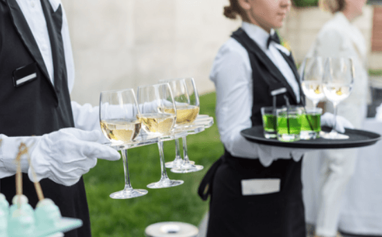 Profissionais servindo bebidas em bandejas, conforme imagem do catálogo